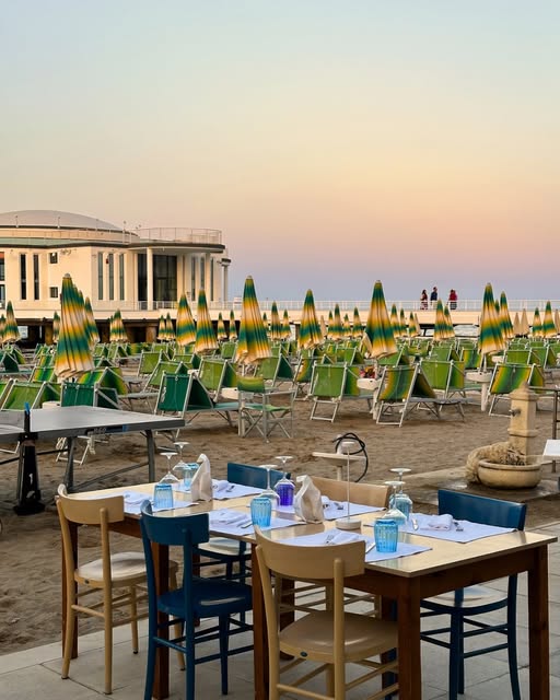 Tavoli in spiaggia al tramonto davanti alla Rotonda a Mare di Senigallia